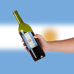 Image showing Hand holding a bottle of red wine