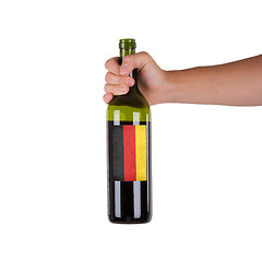 Image showing Hand holding a bottle of red wine