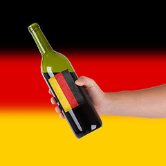 Image showing Hand holding a bottle of red wine