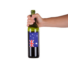 Image showing Hand holding a bottle of red wine