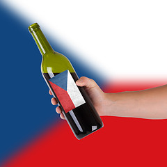 Image showing Hand holding a bottle of red wine