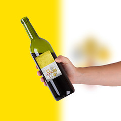 Image showing Hand holding a bottle of red wine