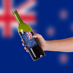 Image showing Hand holding a bottle of red wine