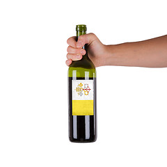 Image showing Hand holding a bottle of red wine