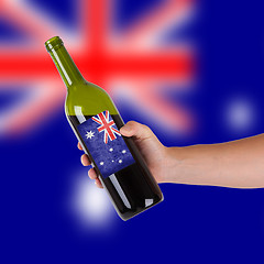 Image showing Hand holding a bottle of red wine