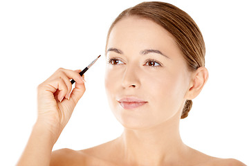 Image showing Beautiful woman with a small cosmetics brush