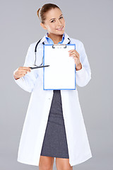 Image showing Female doctor displaying a blank clipboard