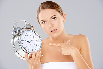 Image showing Bored woman with an alarm clock in her hand