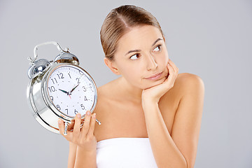 Image showing Bored woman with an alarm clock in her hand