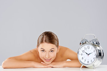 Image showing Smiling relaxed woman with an alarm clock