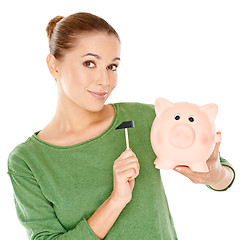 Image showing Woman testing her piggy bank with a mallet