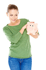 Image showing Woman giving her piggy bank a speculative look