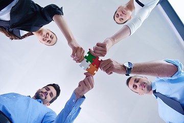 Image showing Group of business people assembling jigsaw puzzle