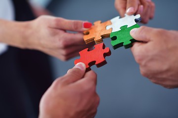 Image showing Group of business people assembling jigsaw puzzle