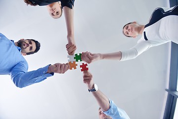 Image showing Group of business people assembling jigsaw puzzle