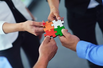 Image showing Group of business people assembling jigsaw puzzle