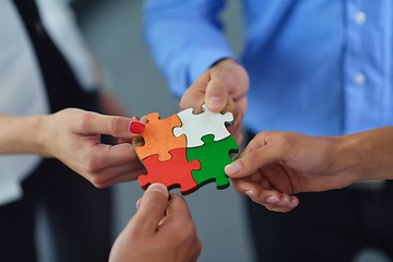 Image showing Group of business people assembling jigsaw puzzle