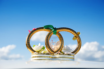 Image showing golden weddings rings over car