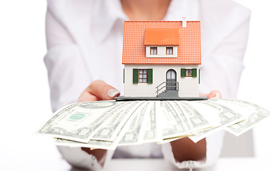 Image showing Hands with money and miniature house on a white background