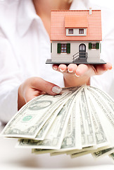 Image showing Hands with money and miniature house on a white background