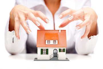 Image showing Female hands and small house