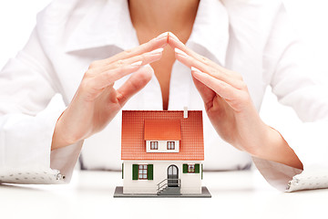 Image showing Female hands saving small house with a roof