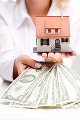 Image showing Hands with money and miniature house on a white background