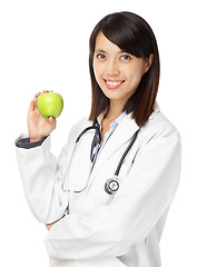 Image showing Asian female doctor holding green apple