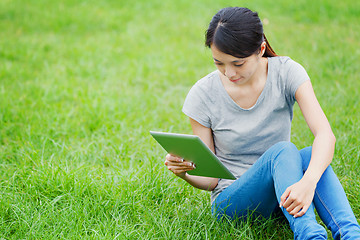 Image showing Woman sitting on grass with tablet computer