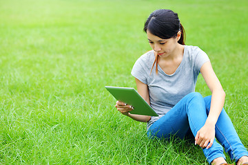 Image showing Asian woman using tablet on grassland