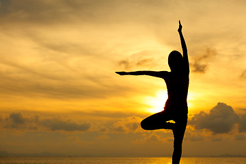 Image showing Silhouette of a woman yoga on sea sunset