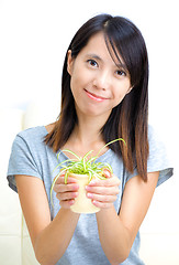 Image showing Asian woman holding potted plant