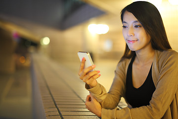 Image showing woman using smartphone in city at night