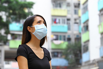 Image showing Woman wearing medical face mask in crowded city
