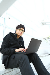 Image showing asian man using computer outdoor