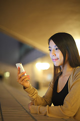 Image showing woman using phone in city at night 