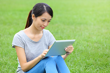 Image showing Woman sitting on grass with tablet computer