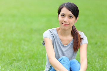 Image showing Asian woman setting on the grass 