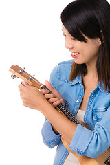 Image showing Asian woman tuning ukelele