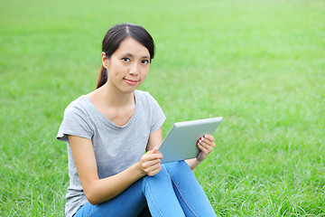 Image showing Woman sitting on grass with tablet computer