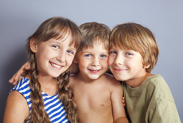 Image showing Cute sister hugging younger brothers