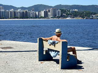 Image showing Senior contemplating the sea sit on the bench