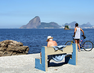 Image showing Senior and man contemplating the sea with The Sugar loaf in the background