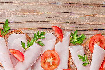 Image showing bread with sliced ham, fresh tomatoes and parsley