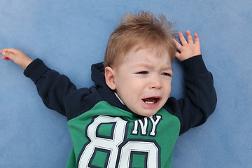Image showing A baby boy crying on a floor