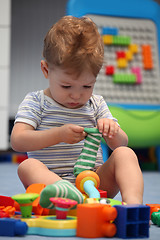 Image showing A funny baby boy trying to dress socks