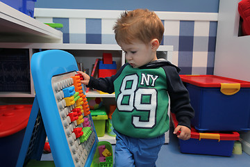 Image showing A baby boy playing with plastic blocks