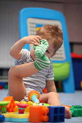 Image showing A funny baby boy trying to dress socks