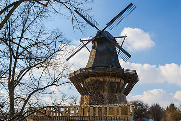 Image showing Traditional old european windmil at forest scenery against blue 