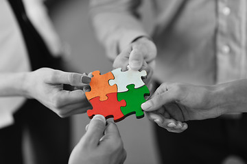 Image showing Group of business people assembling jigsaw puzzle